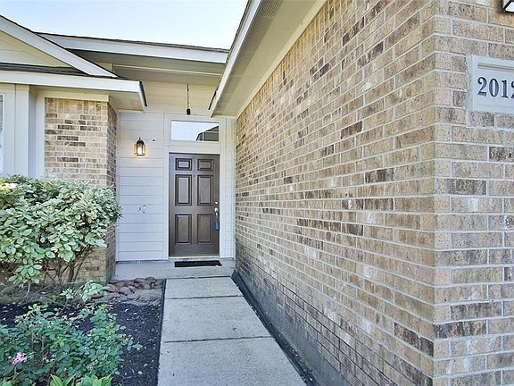 Closeup view of front entrance. Note transom window above front door & nice concrete walkway.