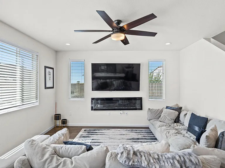 open-concept layout with a spacious great room, elegant electric fireplace, and large windows that fill the home with natural light