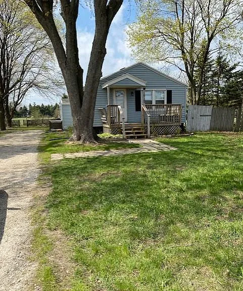 Front View of the House with Porch that has built in seating. Large Tree in Front was recently removed. There is a large grassy area to left of driveway (not visible in this photo).
