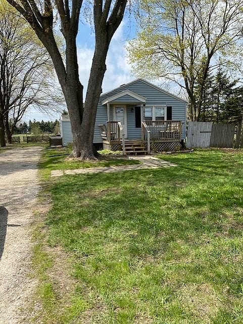 Front View of the House with Porch that has built in seating. Large Tree in Front was recently removed. There is a large grassy area to left of driveway (not visible in this photo).
