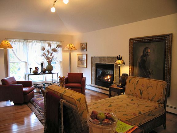 Light-filled living room w/maple flooring & fireplace 