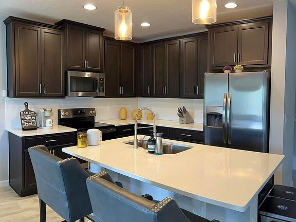 Kitchen area with stainless appliances and quartz countertops