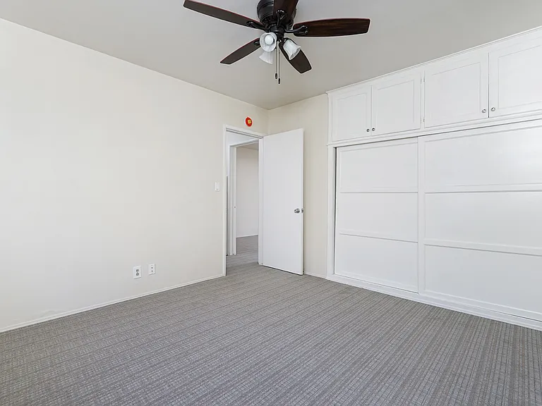 Spacious bedroom with wall-to-wall closets with storage above