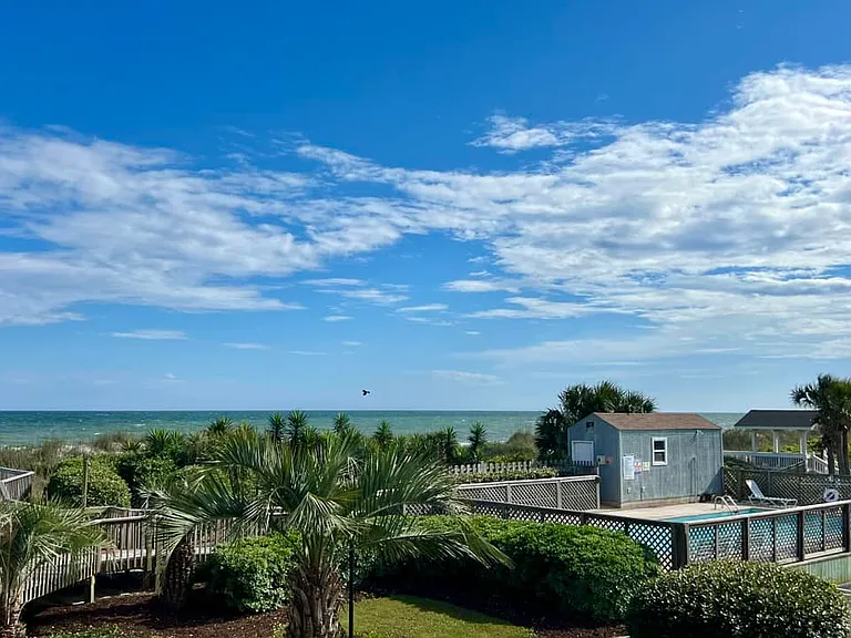 Balcony view... ocean waves, pelicans, pool and beautiful landscaping.
