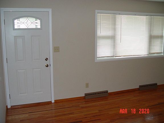 Living room boasts freshly refinished hardwoods and a brand new front door