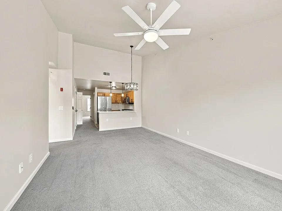 Bright, open living and dining area with vaulted ceiling and sightlines into the kitchen.
