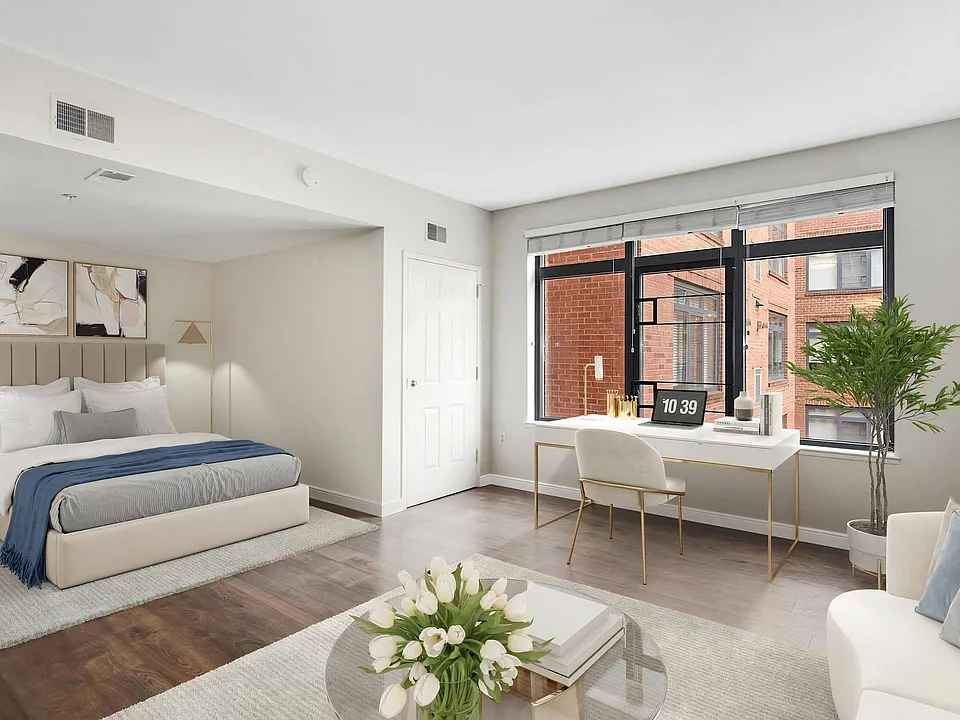 Apartment Interior Showing Sleeping Area, Desk, and Urban Window View