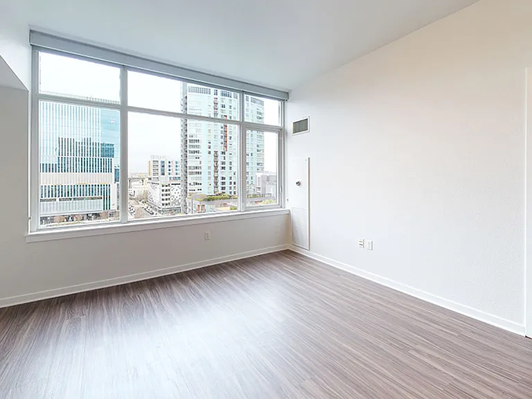 Spacious apartment bedroom with wood-style flooring.