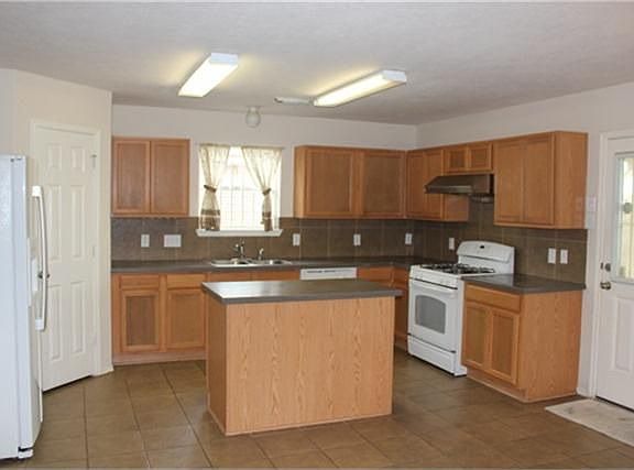 Open kitchen with island, tile floor and tile back splash.