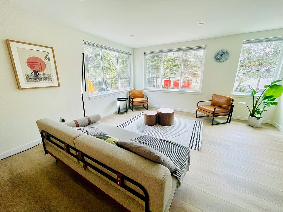 Spacious living room with large windows, natural light.