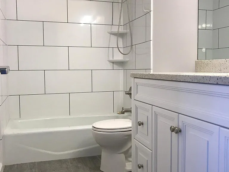 Bathroom has been updated with newer fixtures, flooring, sink cabinet, solid surface countertop and faucet.