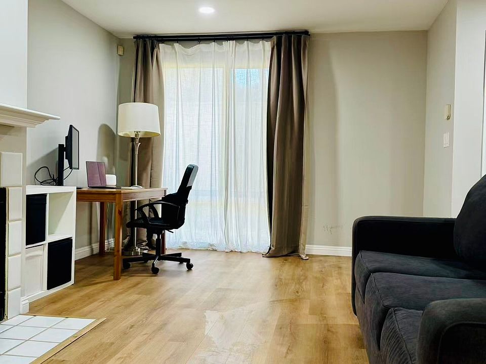 Bright and spacious living room with a fireplace, dedicated work-from-home area, flexible space for yoga or exercise, and a sleeper sofa for overnight guests.