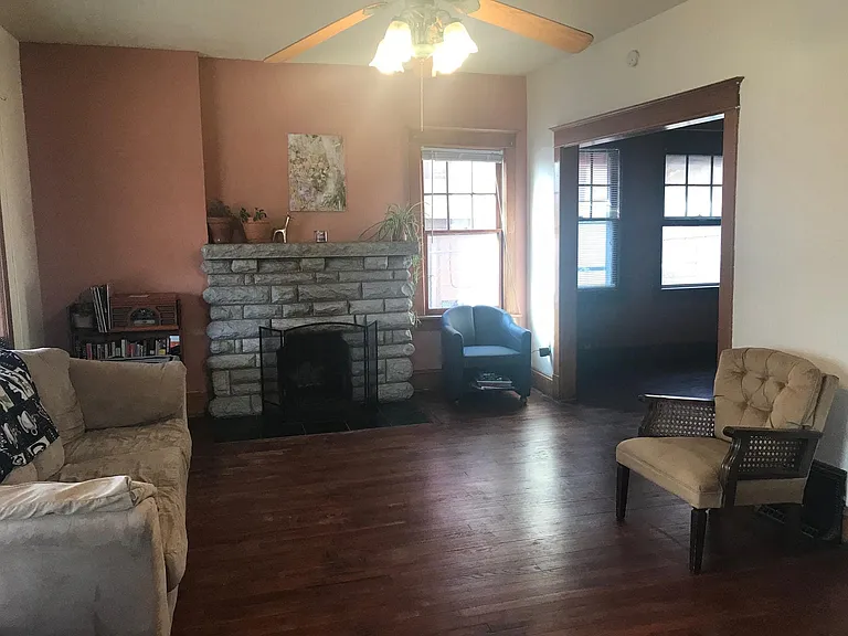 Living room with non-working fireplace, open to the dining room.