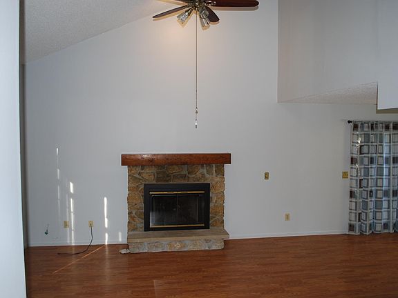 Fireplace, ceiling fan, door to outside patio area