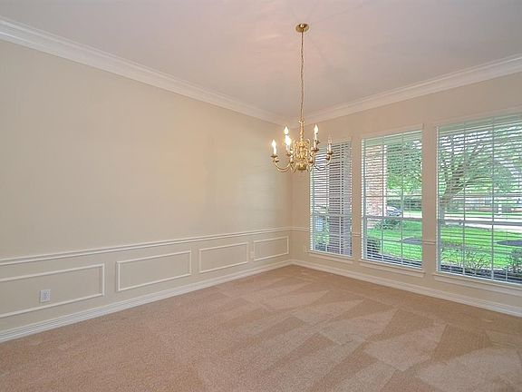 Formal Dining Room with chair rail molding and new carpet and paint. Crown molding and an elegant fixture will create a warm atmosphere when entertaining.