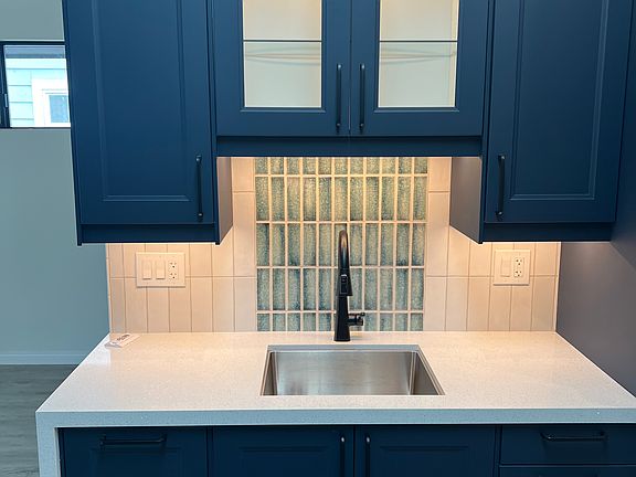 Kitchen sink with quartzite countertop and custom tile.