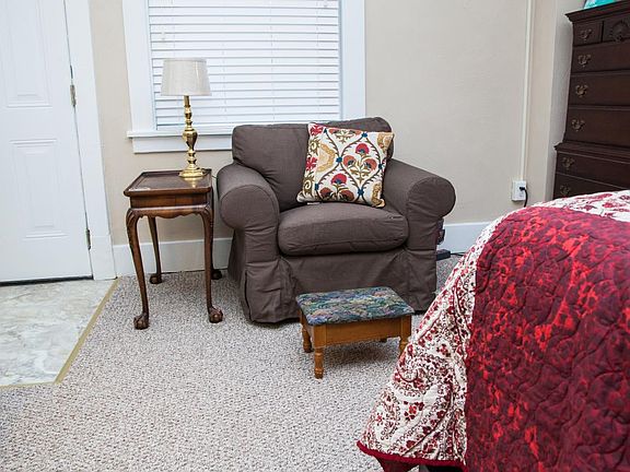 Two comfortable reading chairs, a high dresser, and the back