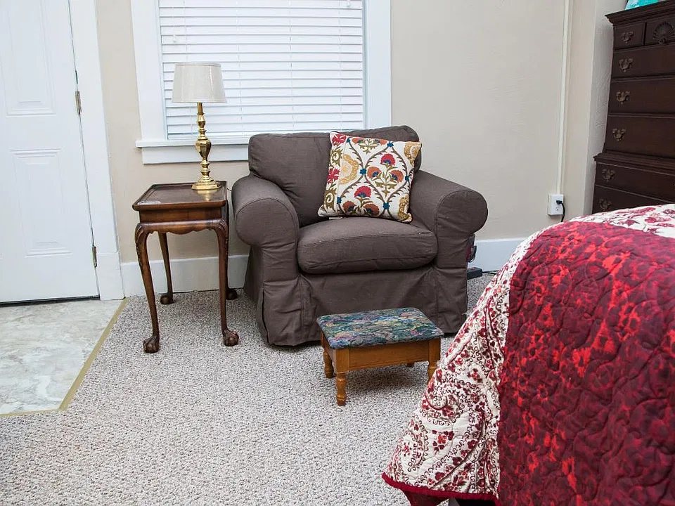 Two comfortable reading chairs, a high dresser, and the back
