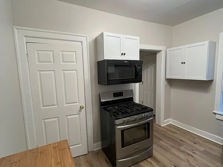 Kitchen with gas stove, stainless steel fridge, mobile kitchen cart, new microwave, and some extra cabinet spacees