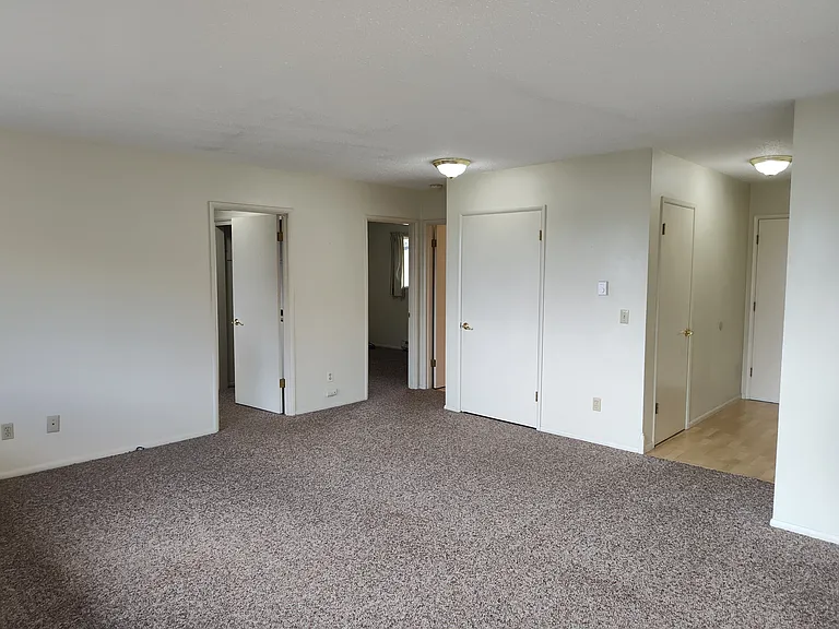 From sliding door showing living room area, entry and bedroom entrances