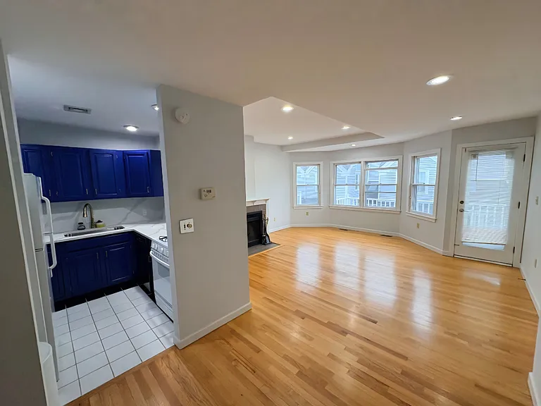 Open-concept living and kitchen area with hardwood floors and abundant natural light.