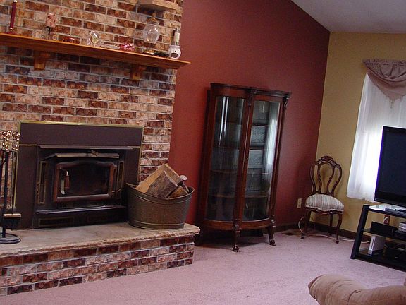 Great Room With Vaulted Ceilings, brick wood burning fireplace, and skylights