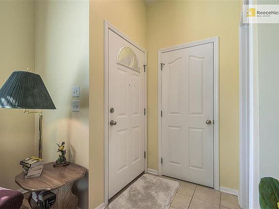 The tiled entrance showing a coat closet and the doorway to the half bath.