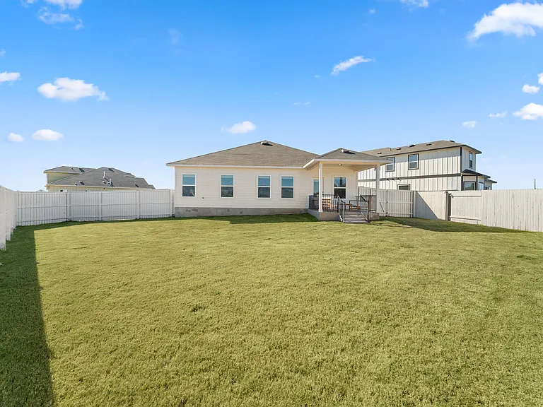 Large backyard has a privacy fence.