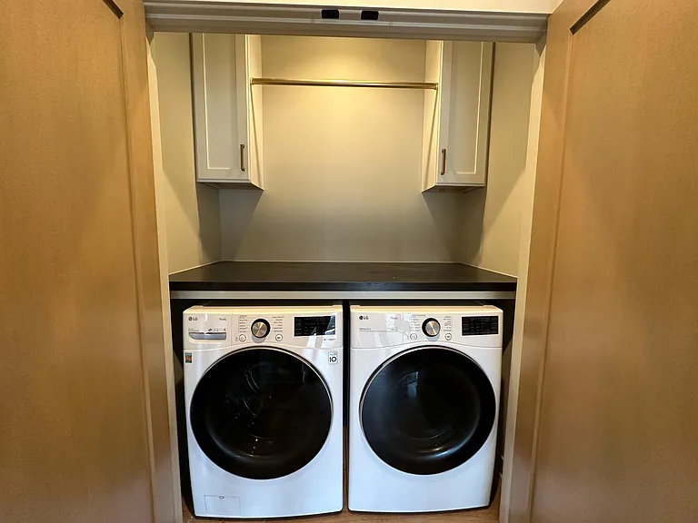 Washer & Dryer with hanging space just outside primary suite.