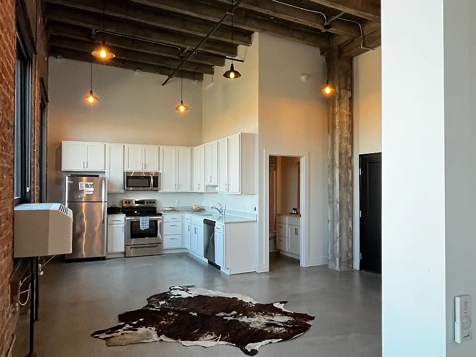 View of kitchen, bathroom, and partial living area from bedroom entrance