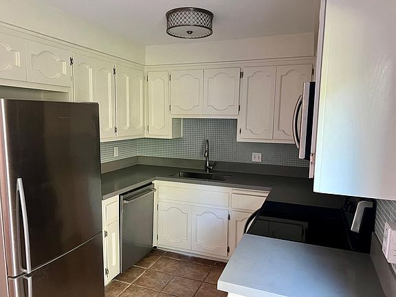 Kitchen with quartz countertops and new stainless appliances.