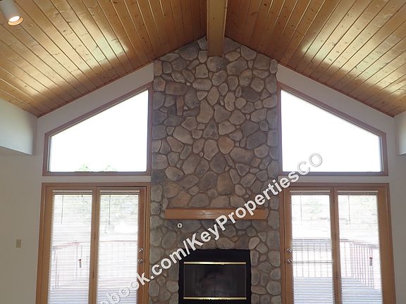 Great room with river rock gas fireplace, wood ceiling, in-floor outlets
