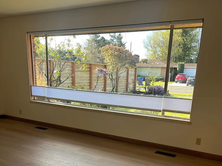 Large, comfortable living room with lots of natural light. It looks out on the front yard and a quiet neighborhood street.
