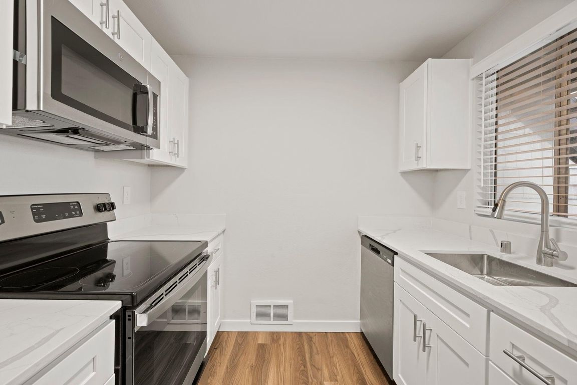 Kitchen with updated quartz countertops and stainless steel appliances