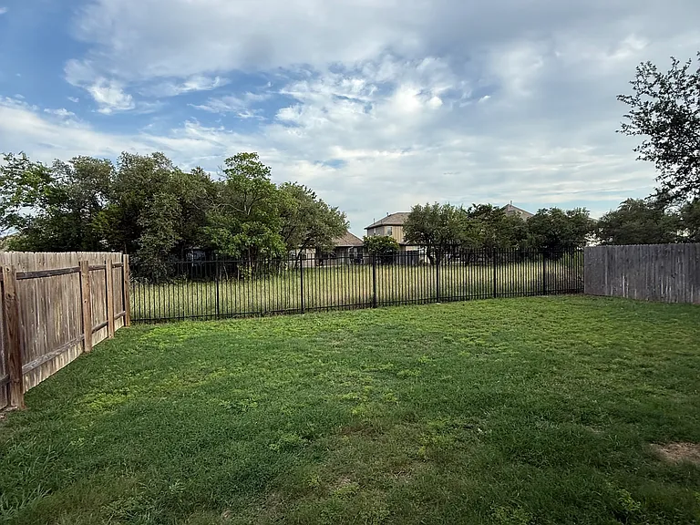 GREEN GRASS ...PRIVATE CAN'T SEE NEIGHBOR DIRECTLY BEHIND...sliding door off Master to back yard and also sliding door on side of home with deck~