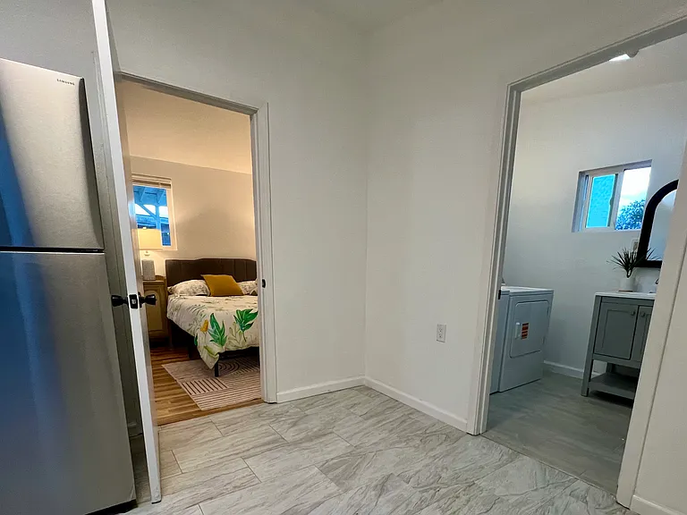 Hallway view showing separation between bedroom and in-unit laundry area