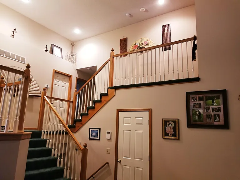 (Old carpet) Living Room view of the bedrooms & staircase. The top floor is the master bedroom and bathroom with a walk in closet. The door on the lower half of the picture leads to the garage.
