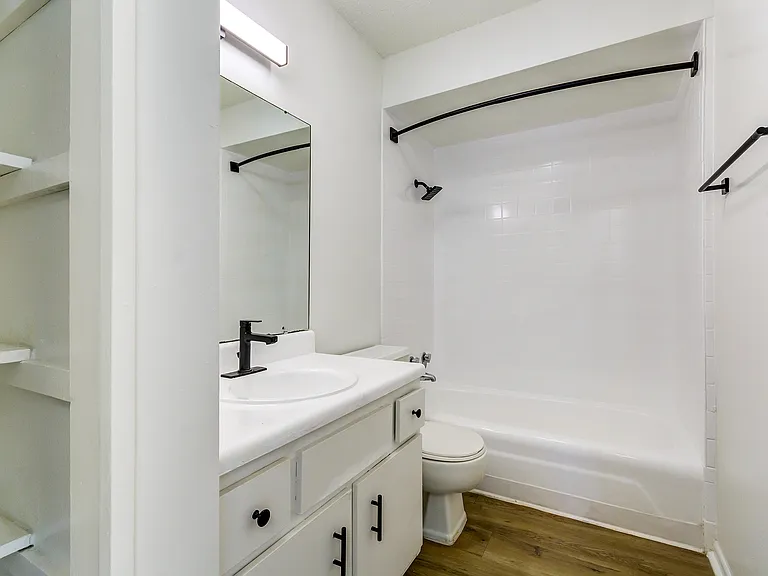A newly renovated bathroom with white cabinetry and black finishes is shown at ReNew on Cantrell.