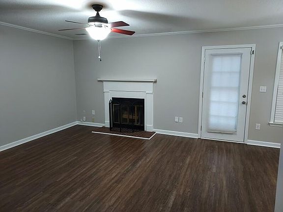 Living room view from hallway, showing fireplace and door to deck.