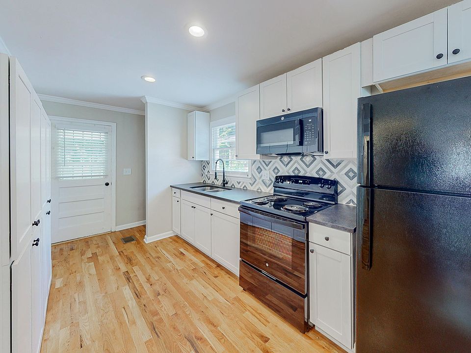 Brand new kitchen with granite countertops and a wall of cabinets on the left side.