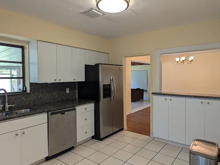 Granite countertops and large side-by-side refrigerator with water and ice dispenser.