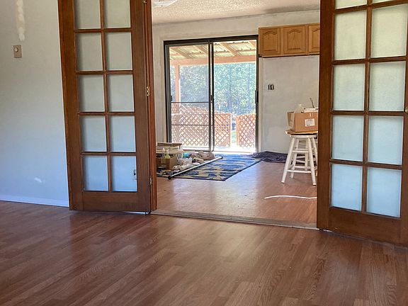 French doors looking from Living Room into Dining Room/Kitchen. Small deck out sliding glass door to backyard and garden area.