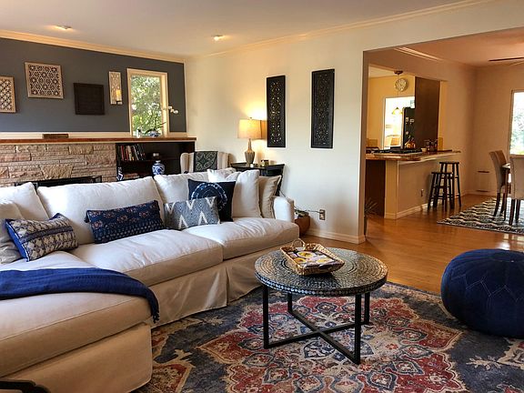 Ample living room with fireplace, flat screen TV. Step to finished garage/exercise studio.