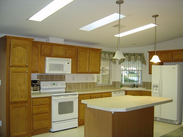 Kitchn features oak cabinets, tile 