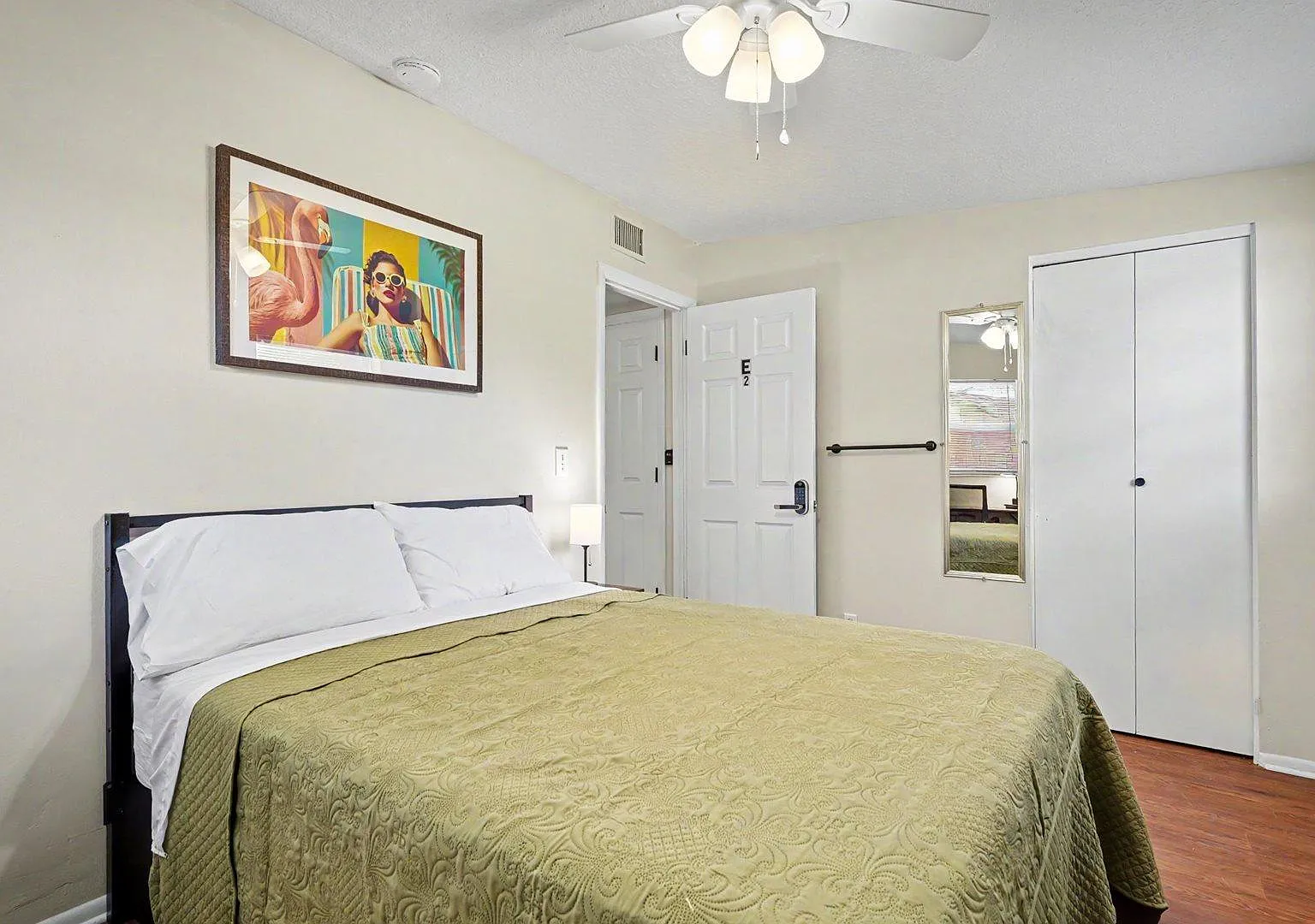 Ample space with a full bed, ceiling fan, a reach-in closet, and wall mounted mirror, plus window blinds for privacy.