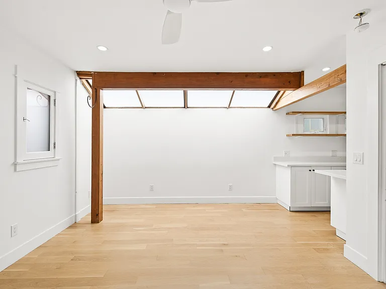 Living room with the bedroom entrance and view of the start of the kitchen