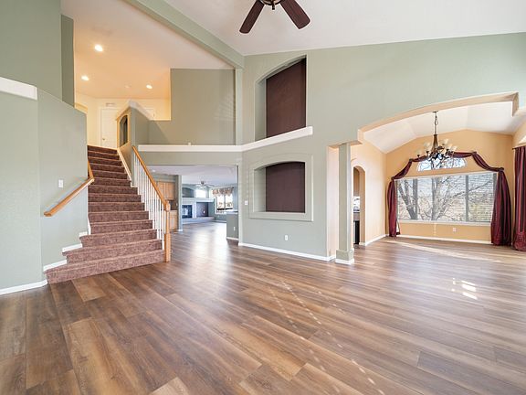 Bright, open living space with soaring ceilings and beautiful, easy-to-maintain, designer plank flooring. Elegant architectural niches, a grand staircase, and arched entryways create a refined yet welcoming setting for daily living and entertaining.