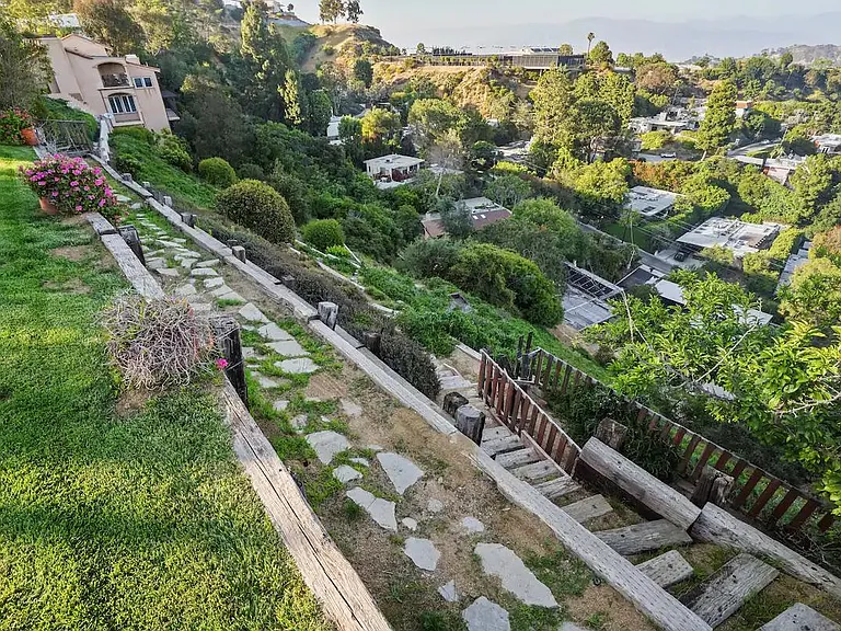Delight in the beautiful garden with steps cascading down the hill, creating a picturesque outdoor escape.