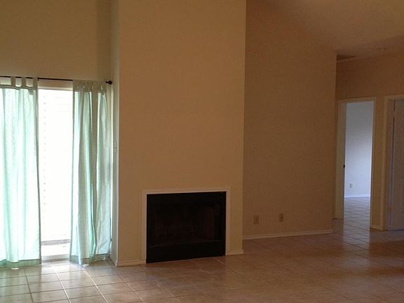 Living room includes fireplace and sliding door to back pati