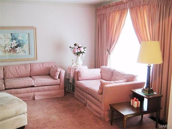The living room has clean carpet and a large, double-paned thermal window to let in plenty of natural light.